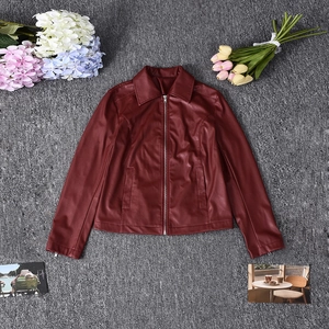 Detail of a slim-fit dark red PU leather jacket featuring a lapel collar and zip pockets