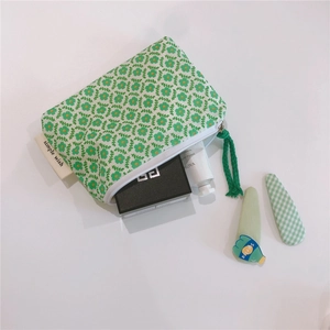 Detail of floral cotton coin purse with green flower pattern and small brand label