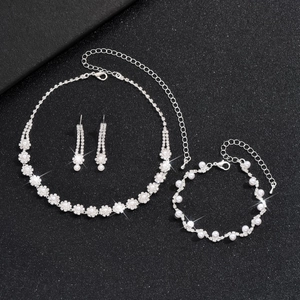 Elegant silver bridal jewelry set with pearls and rhinestones on a black background