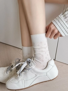 Detailed macro view of white crew socks featuring diamond pattern knit and ribbed cuffs