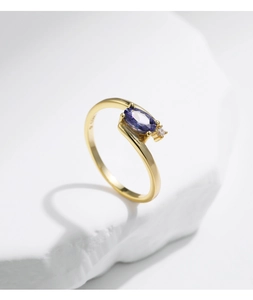 Detail of s925 silver gold-plated ring featuring oval purple stone and round zircon