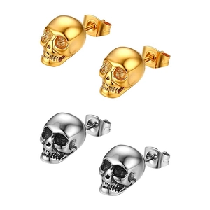 Detail of silver and gold skull stud earrings set with gothic vintage metal textures