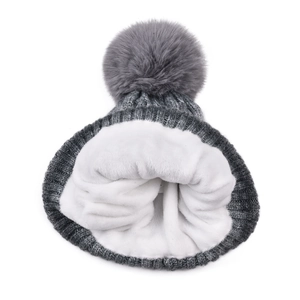 Close-up of thick fleece lining and gray knit texture of the winter pom-pom hat