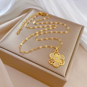 Detailed close-up of a golden spinning flower necklace with inlaid crystals in a gift box