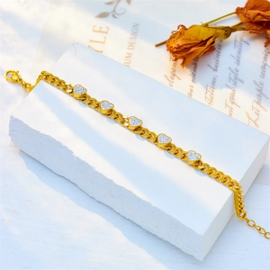 Elegant gold titanium steel bracelet with five white crystal heart charms on marble decor