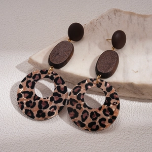 Detail of vintage geometric earrings with wood studs and leopard print acrylic hoops