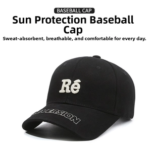 Close-up of black baseball cap with white towel-embroidered Re letters and detail stitching