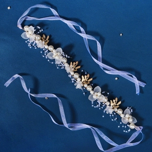 Detail of bridal headband with gold leaves, white flowers, pearls and lavender ribbon
