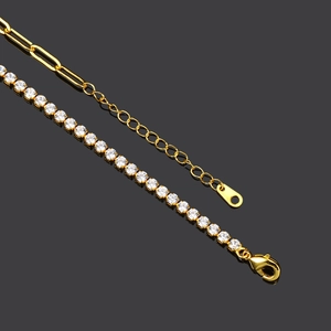 Detailed close-up of gold paperclip chain and zircon tennis necklace with lobster clasp
