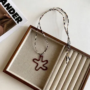 Detail of vintage star pendant with leopard print cord on beige fabric jewelry display