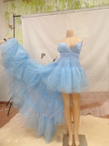 Detail of light blue high-low tulle wedding dress with star sequins and layered mesh fabric