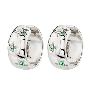 Close-up of silver huggie hoop earrings with star engravings and green zircon stones