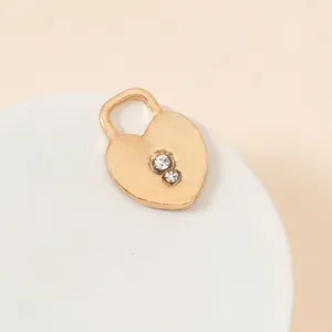 Macro shot of a matte gold heart lock pendant with two sparkling clear cubic zirconia stones