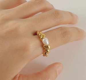 Macro detail of 18k gold plated twisted rope ring band with a natural white pearl accent