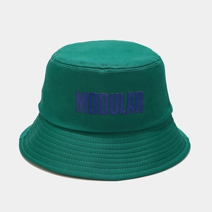 Dettaglio di un cappello a secchiello verde scuro con stampa MODULAR viola e trama twill