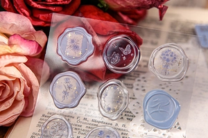 Macro shot of 3D embossed rose and butterfly wax seal stickers with gold foil detailing