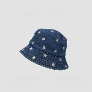 Detail of white daisy flower embroidery on premium blue denim fisherman bucket hat