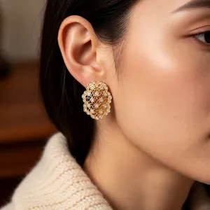 Vintage gold hollow floral stud earrings with sparkling zircons worn by a model
