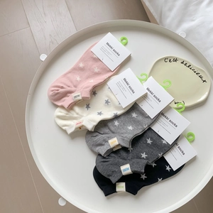 Detailed set of five cotton socks in pastel colors with star patterns on a white tray