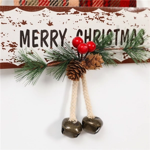 Detail of wooden Merry Christmas hanging sign with pine needles, cones and bronze bells