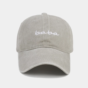 Gros plan de la broderie baba blanche sur la casquette en coton délavé gris-vert