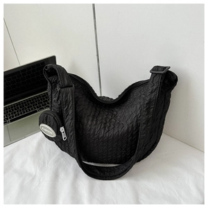 Detail of black pleated crescent bag featuring a mini 'FASHION' coin purse charm