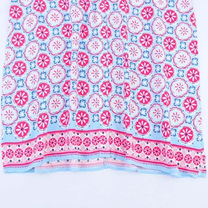 Detail of pink floral and blue geometric patterns on a bohemian V-neck midi dress
