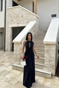 Close-up of elegant black halter dress featuring sexy cutout and ruched waist detail
