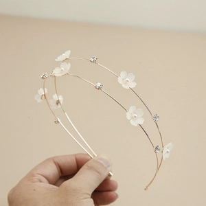 Detail of double-layer golden headband with white flowers, pearls, and rhinestones