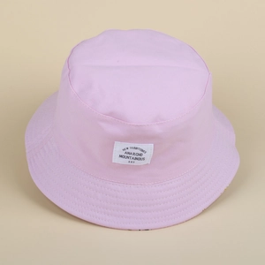Detail of pink cotton bucket hat featuring a flat crown and embroidered white text patch