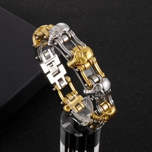 Macro shot of two-tone stainless steel skull bike chain bracelet on a round stand