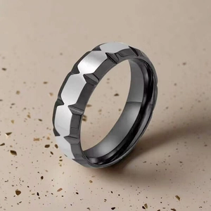 Primer plano del patrón geométrico bicolor con corte de diamante del anillo de titanio