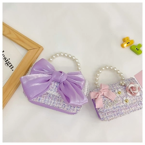 Close-up of purple tweed girl bags with pearl handles and decorative bow accents