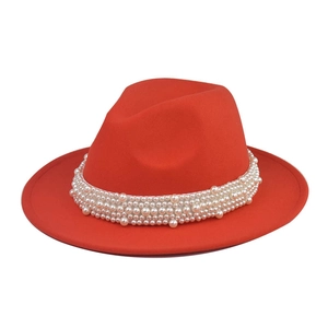 Detalle de sombrero fedora rojo de lana con banda decorativa de perlas elegantes