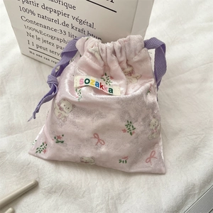 Detailed close-up of pink velvet bear drawstring pouch with soft texture and purple ropes