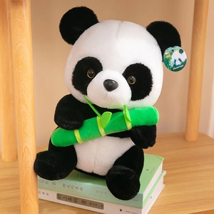 Adorable panda plush toy holding green bamboo sitting on books as a perfect gift choice