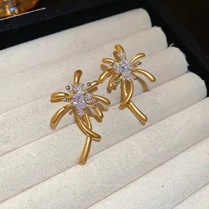 Elegant gold fireworks stud earrings with sparkling cubic zirconia on soft velvet tray