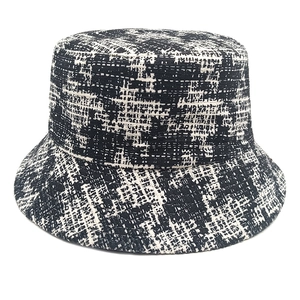 Close-up of black and white houndstooth tweed bucket hat with textured woven fabric