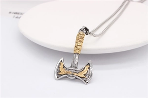 Detail of Viking double eagle axe pendant with golden accents and textured handle