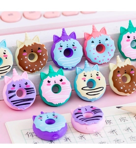 Close-up of colorful unicorn donut erasers in pink, blue, and yellow on a white stand