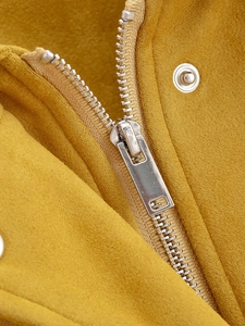 Detail of metal zipper and snap buttons on yellow faux suede casual jacket