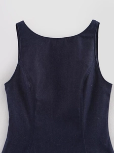Détail d'un haut sans manches en denim bleu foncé avec des coutures structurelles