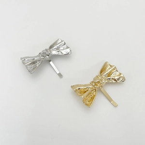 Detail view of gold and silver alloy hair hooks with minimalist metallic crinkle texture