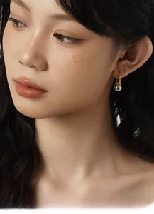 Close-up of vintage S925 silver ear hoop with grey pearl on an Asian woman model