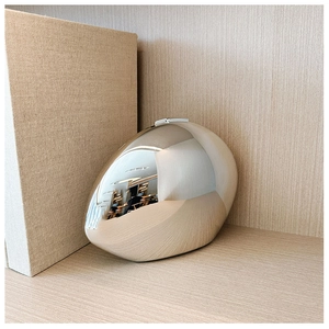 Close-up of pebble-shaped silver metallic clutch bag with a mirror-finish and top clasp