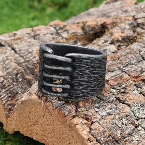 Vintage industrial style wide stainless steel ring with rock texture on bark background