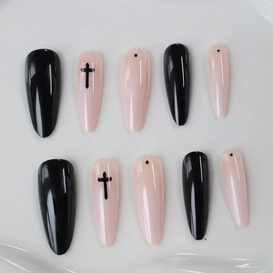 Gothic long almond press-on nails featuring black crosses and dots on pink and black polish