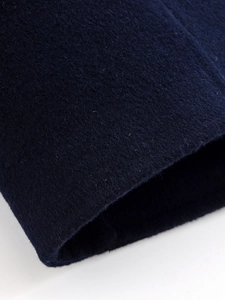 Macro shot of dark blue wool blend fabric texture and detailed sleeve cuff stitching