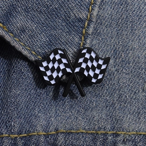 Macro view of racing theme checkered flags enamel lapel pin on blue denim fabric