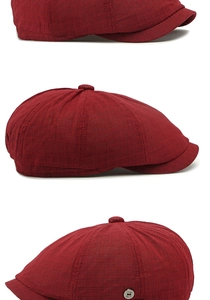 Detailed macro view of dark red newsboy cap with breathable mesh texture and metal logo